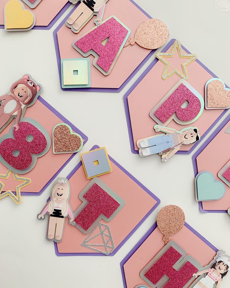 Puede incluir: Bandera rosa y morada con la palabra "Happy" en letras de purpurina rosa. Cada letra est&aacute; en una tarjeta separada con forma de hex&aacute;gono con varias decoraciones, incluyendo estrellas, corazones y un personaje de Roblox.