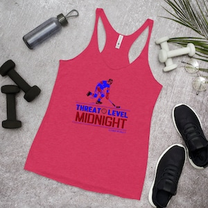 May include: A red tank top with a hockey player graphic and the text "Threat Level Midnight" in blue and red. The text "Clem's On A Roll" is in smaller font below the main text.
