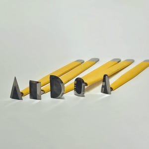 May include: Set of six yellow-handled sculpting tools with different shaped metal tips, including a triangle, square, half-circle, oval, and two different shaped rounded tips.
