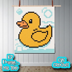 May include: A pixelated yellow duck design on a white background, with blue bubbles and water details. The artwork is displayed on a wooden rod with leather straps. The text "KP Design Me Too" and "C2C Crochet" are visible.