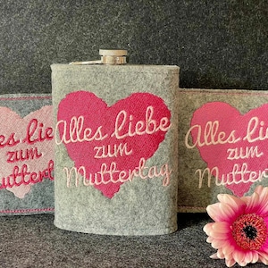 Può includere: Tre sacchetti di feltro grigi con cuori rosa e il testo "Alles Liebe zum Muttertag" ricamato su di essi. I sacchetti sono per regali e sono perfetti per la Festa della Mamma.