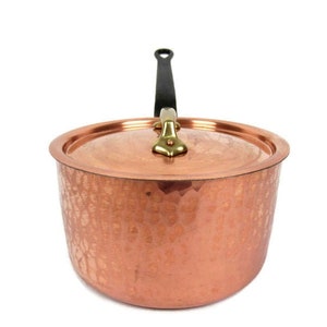 May include: A copper saucepan with a hammered finish and a black handle. The saucepan has a lid with a brass knob.