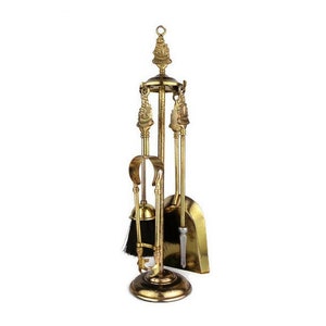 Op de afbeelding: Een gouden metalen haardgereedschapset met een borstel, schep, poker en tang. De gereedschappen zijn gemonteerd op een decoratieve standaard met een ronde basis.