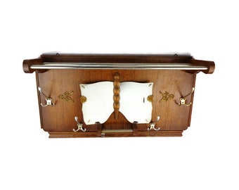 May include: A vintage wooden coat rack with a chrome rail and multiple hooks. The rack has a decorative design with a mirror and ornate details.