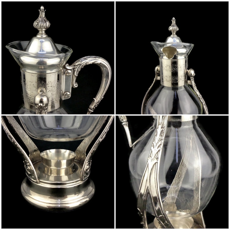 May include: Silver plated glass coffee pot with a decorative stand. The pot has a clear glass body and a silver plated lid with an ornate design. The stand has a round base and three legs.