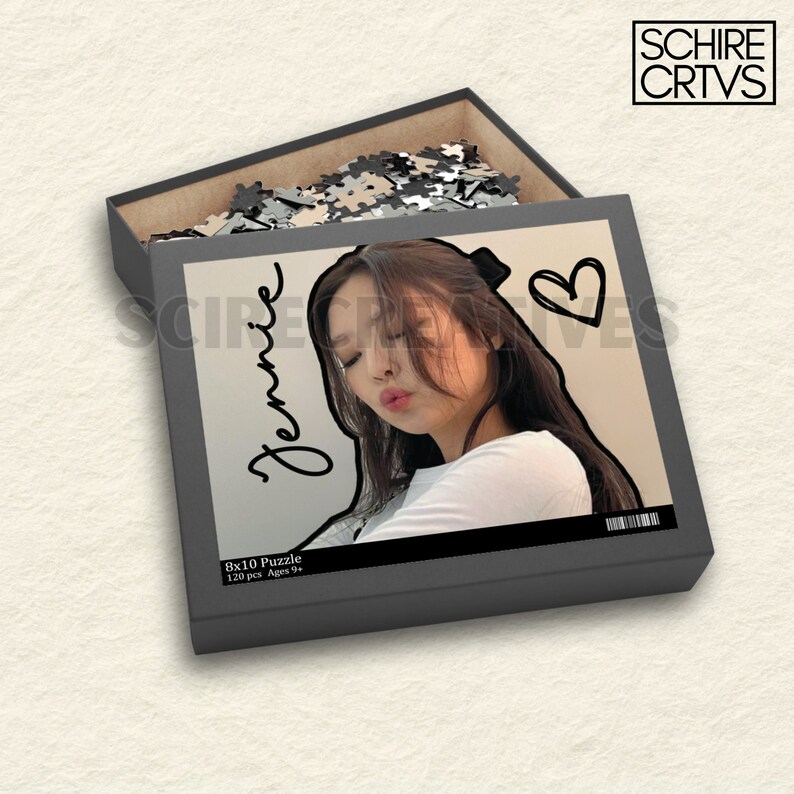 Może przedstawiać: Czarno-szare pudełko z puzzlami z fotografią kobiety na przodzie. Pudełko jest oznaczone "Jennie" i "8x10 Puzzle 120 pcs Ages 9+".