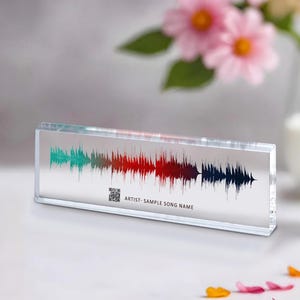 May include: A clear acrylic block with a colorful sound wave design and a QR code. The text "ARTIST - SAMPLE SONG NAME" is printed below the sound wave.