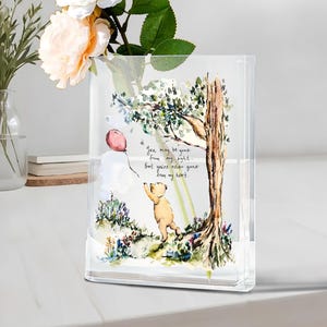 Könnte beinhalten: Ein klarer, rechteckiger Glasblock mit einer Aquarellillustration eines Bären und eines rosa Ballons. Das Bild enthält einen Baum und den Text: "You may be gone from my sight... But you're never gone from my heart."