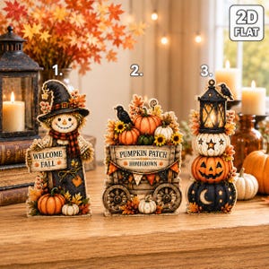 Puede incluir: Tres decoraciones de madera planas en 2D para el otoño. La primera es un espantapájaros con un cartel que dice WELCOME FALL. La segunda es un carro con la etiqueta PUMPKIN PATCH HOMEGROWN y calabazas. La tercera es una pila de tres calabazas.