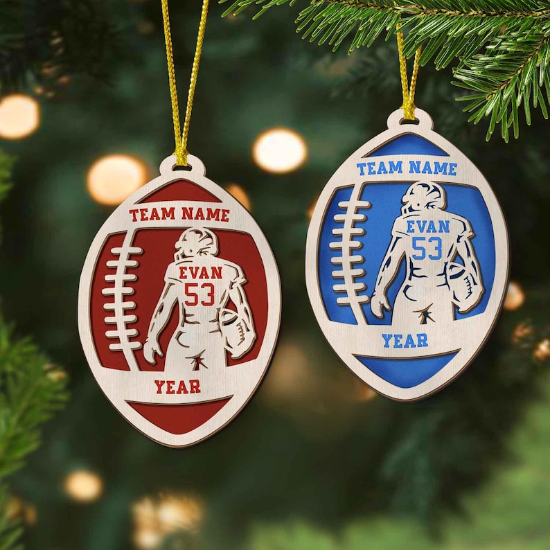 May include: Two wooden football ornaments with a player in the middle. The ornament on the left is red and says "Team Name", "Evan 53", and "Year". The ornament on the right is blue and says "Team Name", "Evan 53", and "Year".