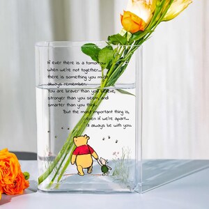 May include: A clear glass vase with a Winnie the Pooh and Piglet illustration, holding yellow and orange roses. The vase has a quote: "If ever there is a tomorrow when we're not together... I'll always be with you."
