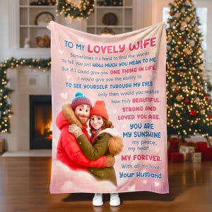 May include: A pink blanket with a printed message to a wife, featuring a cartoon couple in winter attire. The text includes phrases like "To My Lovely Wife" and "You Are My Sunshine."
