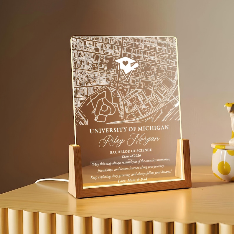 May include: A lighted acrylic map of the University of Michigan, personalized with a name, degree, and class year. The map is set in a wooden frame and includes a heartfelt message. A unique graduation gift.