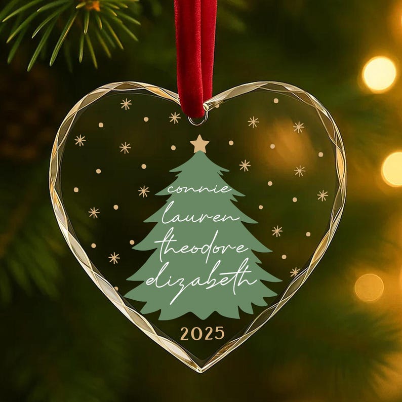 May include: Heart-shaped Christmas ornament with a green Christmas tree design and the names "Connie, Lauren, Theodore, Elizabeth" in white script. The year "2025" is printed at the bottom. The ornament hangs from a red ribbon.