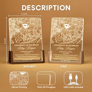 May include: Two illuminated acrylic map plaques, 8 inches tall and 6 inches wide, with a wooden base. The plaques feature a map of the University of Michigan, personalized with a name and graduation details. One has a walnut base, the other oak.