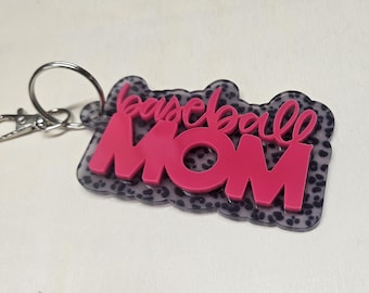 May include: Pink keychain with a leopard print background and the words "baseball mom" in white lettering.