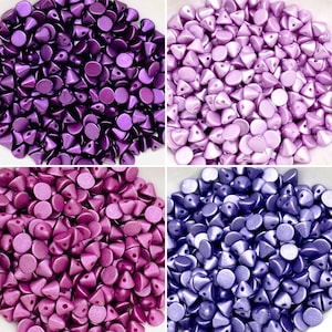 May include: Four close-up images of various shades of purple, pink, and blue iridescent round beads with a pointed top. The beads are arranged in a pile.