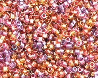 May include: A close-up of a large quantity of small, round, iridescent glass beads in shades of pink, purple, and gold. The beads are perfect for jewelry making, beading projects, and crafts.