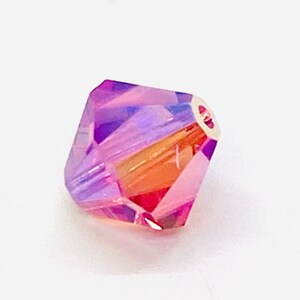 Peut inclure: Une seule perle de cristal iris&eacute;e violette et orange avec un design facett&eacute;.