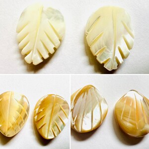 May include: Four leaf-shaped pendants with carved details. Two are a creamy white color, and two are a golden yellow. The leaf veins are visible, and the pendants have a pearlescent sheen.