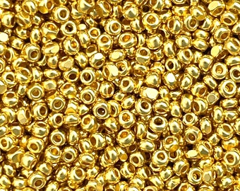 May include: A close-up image of a large quantity of gold-colored seed beads. The beads are small and round with a hole in the center. They are perfect for jewelry making and other craft projects.