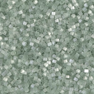 May include: A close-up of a large quantity of small, light green, glass seed beads. The beads are opaque and have a slightly iridescent finish.