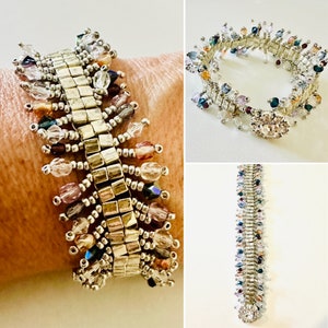 May include: A beaded bracelet featuring a central row of metallic square beads flanked by dangling multi-colored crystal beads in shades of clear, pink, blue, and amber. The bracelet includes a circular, rhinestone-encrusted clasp closure.