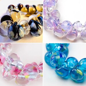 May include: Four strands of glass beads in different colors and patterns. The first strand is black and white, the second is purple and white, the third is pink and white, and the fourth is blue and white.
