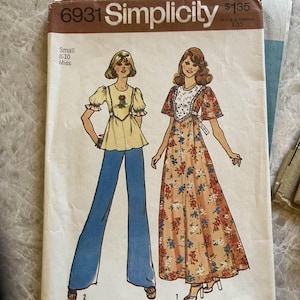 Könnte beinhalten: Vintage Simplicity Schnittmusterumschlag. Der Umschlag zeigt Illustrationen von zwei Frauen in Kleidung der 1970er Jahre. Eine trägt ein gelbes Oberteil und blaue Hosen, die andere ein Blumenkleid. Der Umschlag ist mit "6931 Simplicity" beschriftet.