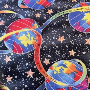 May include: A black fabric with a repeating pattern of colourful globes and stars. The globes are surrounded by a blue ribbon with the text "world wide web.com" and "http://www.worldwide web.com".