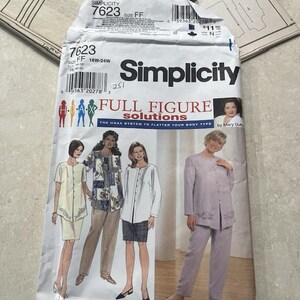 May include: Simplicity sewing pattern 7623 for full figure solutions. The pattern packet features illustrations of women in various outfits, including a skirt suit, pantsuit, and blouses. The packet is white with black and red text.