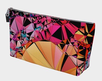 Puede incluir: Una bolsa negra con cremallera con un patrón geométrico en tonos de rosa, naranja, amarillo y azul. El patrón está formado por triángulos y cuadrados.