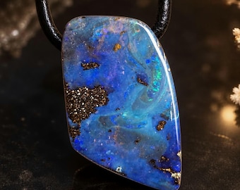 May include: A polished boulder opal pendant with a smooth, irregular shape suspended from a black leather cord. The stone features vibrant swirls of deep blue and turquoise with embedded dark brown and metallic gold mineral inclusions.