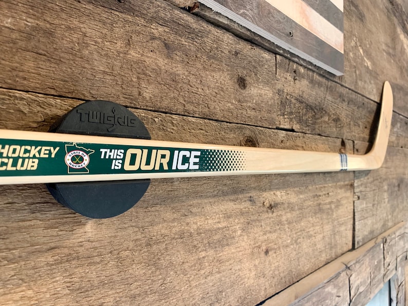 An autographed MN Wild hockey stick mounted to a wall with the TwigRig hockey stick holder