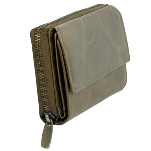 May include: A sage green leather wallet with a zip-around closure and a flap. The wallet has a textured appearance and a metal zipper pull. The design includes multiple compartments for cards and cash. The wallet is a compact size.