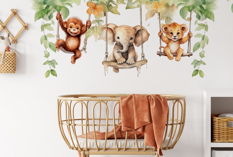 May include: A nursery wall decal featuring a monkey, elephant, and lion swinging on vines. The animals are painted in a watercolour style with a whimsical and playful design. The decal is perfect for adding a touch of jungle fun to a child's room.