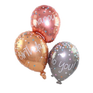 May include: Three gold foil balloons with confetti print. The balloons have the text "Happy Birthday to you!" printed on them.