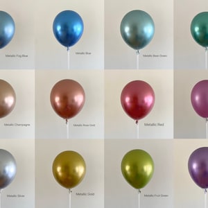 May include: Twelve metallic balloons in various colors, including blue, green, red, pink, gold, silver, and champagne. The balloons are arranged in four rows of three, with each balloon on a white stick.