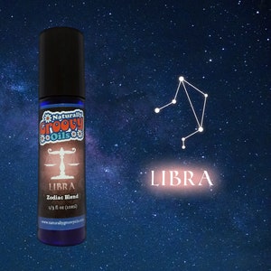 May include: A blue glass bottle with a black cap and a white label. The label says "Naturally Groovy Oils" and features a Libra zodiac symbol. The text on the label also says "LIBRA Zodiac Blend 1/3 fl oz (10ml) www.naturallygroovy.com".