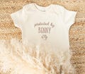 Embroidered Protected By Dog Baby Onesie®: Personalized Newborn Gift for Pregnancy Announcement