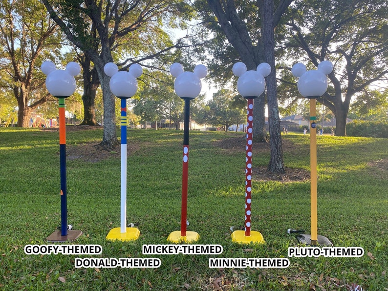 Tall outdoor lamps. The top is what and looks like a Mickey Mouse silhouette. The poles for the lamps are themed to popular characters.