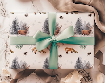 May include: A white gift box with a green ribbon and bow. The box is wrapped in paper with a winter forest scene featuring deer, foxes, and pine trees. The text "Season's Greetings" is visible on the box.