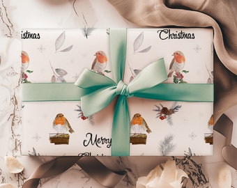 May include: A white gift box with a green ribbon and bow. The box is wrapped in paper with a repeating pattern of red robins, snowflakes, and sprigs of greenery. The text "Christmas" and "Merry Christmas" is printed on the box.