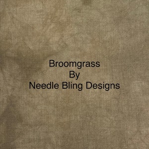 May include: Close-up of a tan fabric with a woven texture. The text "Broomgrass By Needle Bling Designs" is printed in black, centered on the fabric. The fabric has a subtle, natural appearance.