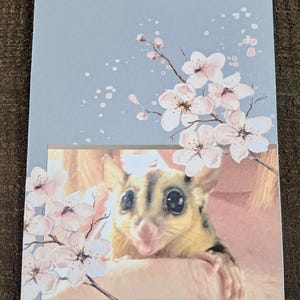 Cartão de felicitações fofo de Sugar Glider com flores rosa
