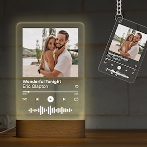 May include: A personalized night light and keychain featuring a photo of a couple. The night light is rectangular with a wooden base and displays the song "Wonderful Tonight" by Eric Clapton. The keychain has the same design.