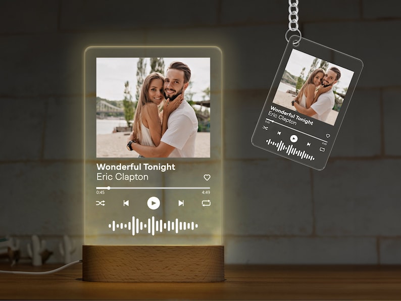 May include: A personalized night light and keychain featuring a photo of a couple. The night light is rectangular with a wooden base and displays the song "Wonderful Tonight" by Eric Clapton. The keychain has the same design.