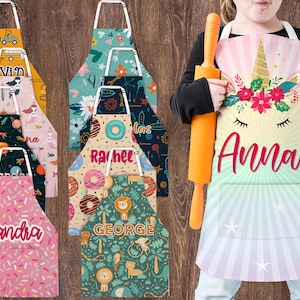 May include: A set of ten colorful personalized aprons with various designs, including a unicorn, donuts, and a jungle scene. Each apron has a name printed on it, such as "Kevin", "Anna", and "Sandra".