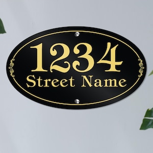 May include: Black oval house number sign with gold lettering. The number 1234 and the words "Street Name" are displayed on the sign.
