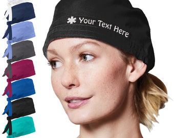 May include: A black scrub hat with a white star of life and the text "Your Text Here" embroidered on the front. The hat is worn by a person with blonde hair. The hat is available in a variety of colors.